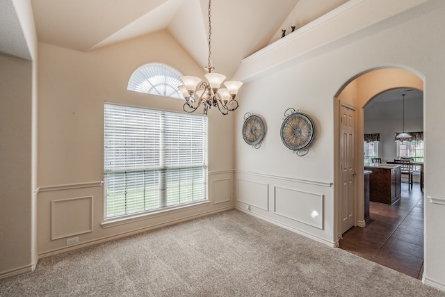 empty room featuring high vaulted ceiling and dark carpet