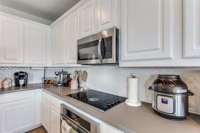 kitchen featuring white cabinetry, backsplash, and stainless steel appliances