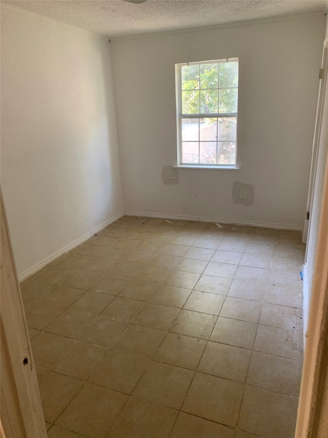 tiled spare room with a textured ceiling