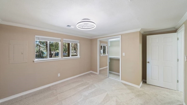 unfurnished bedroom with a closet, crown molding, electric panel, and light colored carpet