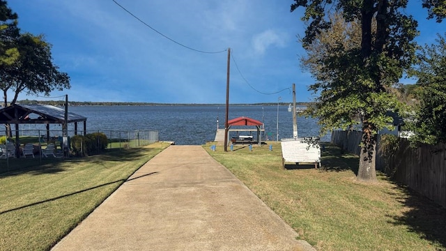 dock area featuring a water view, a gazebo, and a yard