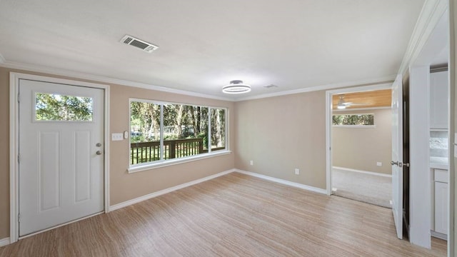 foyer entrance featuring crown molding, light wood-type flooring, and a wealth of natural light