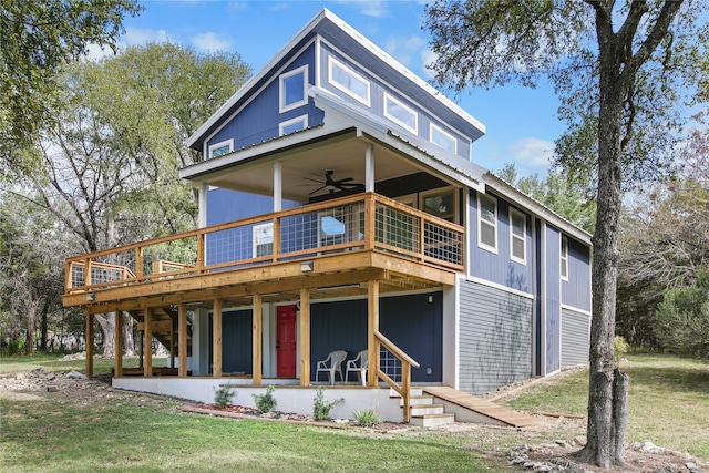 view of front of home with a front yard, a wooden deck, and ceiling fan