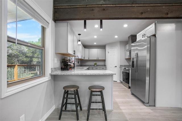 kitchen featuring white cabinets, stainless steel appliances, light hardwood / wood-style floors, and plenty of natural light