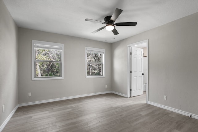 empty room with light hardwood / wood-style flooring and ceiling fan