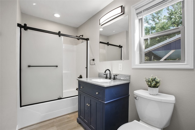 full bathroom featuring toilet, combined bath / shower with glass door, vanity, and wood-type flooring