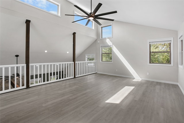 unfurnished living room featuring ceiling fan, a wealth of natural light, and hardwood / wood-style floors