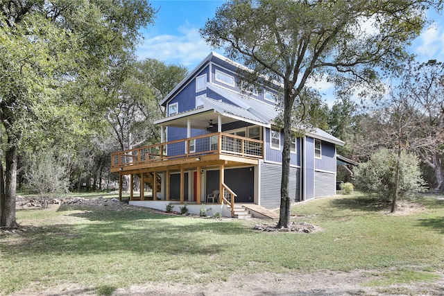 rear view of property featuring a wooden deck, a yard, and ceiling fan