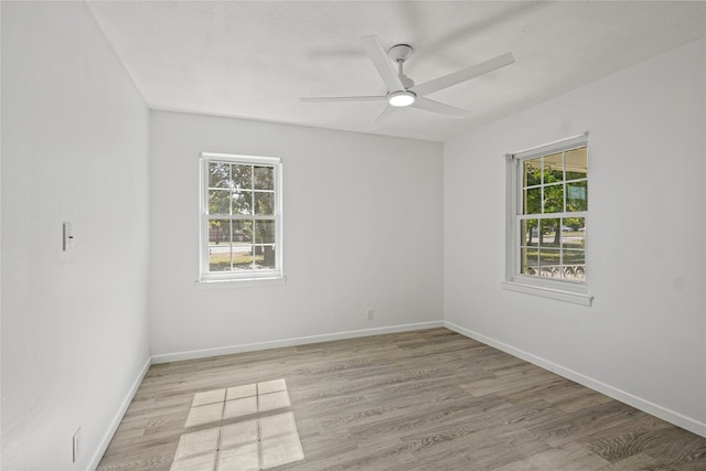 unfurnished room featuring ceiling fan, light hardwood / wood-style flooring, and a healthy amount of sunlight