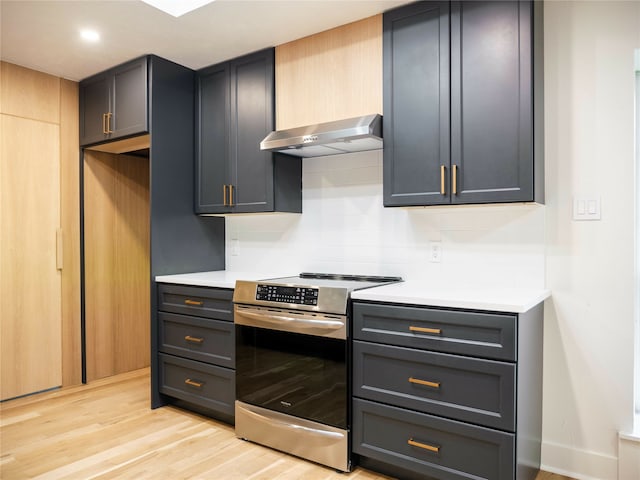 kitchen with light hardwood / wood-style flooring, decorative backsplash, exhaust hood, and stainless steel range