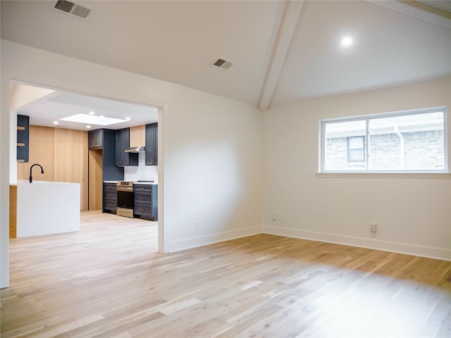 empty room with sink, vaulted ceiling with beams, and hardwood / wood-style flooring