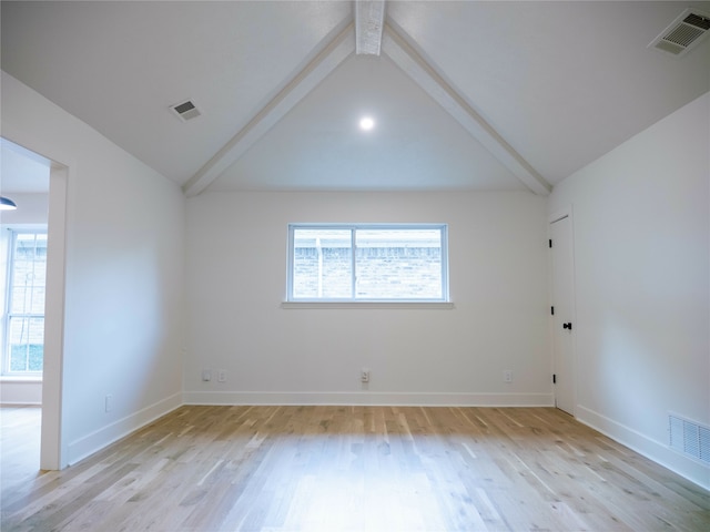 empty room featuring light hardwood / wood-style flooring and vaulted ceiling with beams