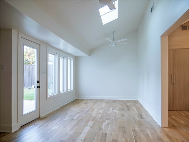 interior space featuring lofted ceiling with skylight, light hardwood / wood-style flooring, and ceiling fan