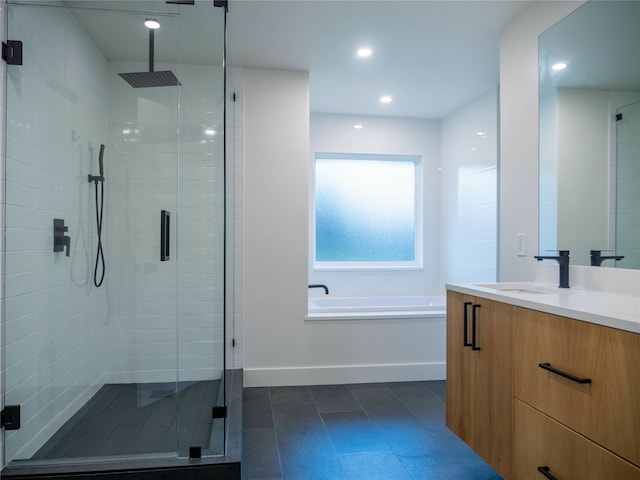 bathroom with vanity and shower with separate bathtub