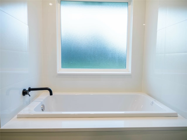 bathroom with a tub and a healthy amount of sunlight