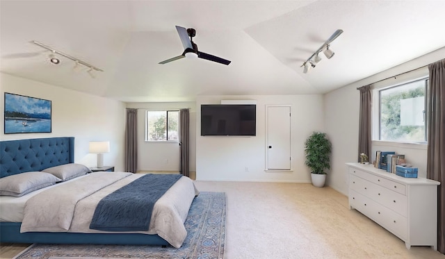 bedroom with lofted ceiling, track lighting, light colored carpet, and ceiling fan