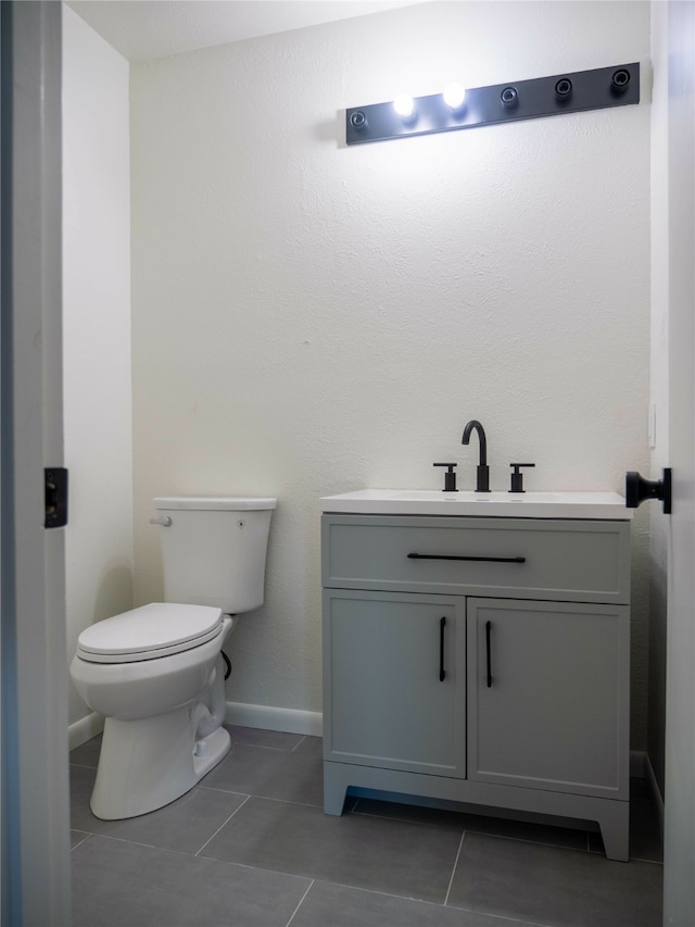 bathroom featuring toilet, vanity, and tile patterned flooring