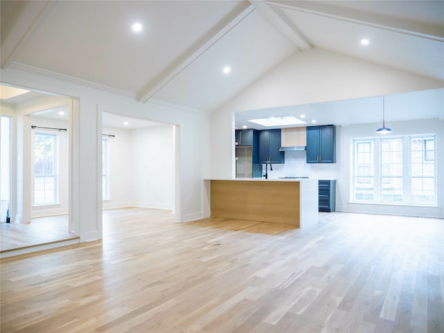 unfurnished living room with beam ceiling, high vaulted ceiling, wood-type flooring, and a healthy amount of sunlight