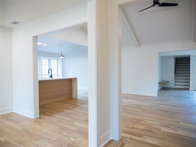 hallway with lofted ceiling with beams and light wood-type flooring