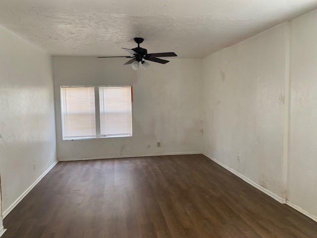 unfurnished room with ceiling fan and dark hardwood / wood-style floors