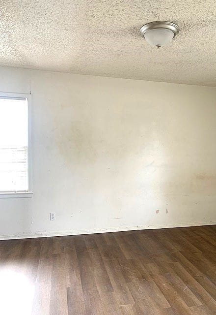 unfurnished room featuring hardwood / wood-style floors and a textured ceiling