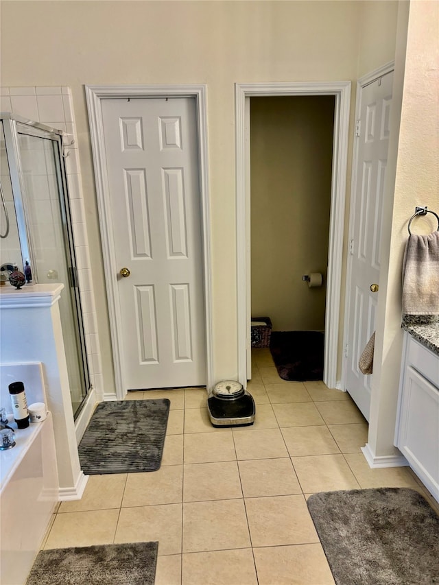 bathroom with vanity, an enclosed shower, and tile patterned flooring