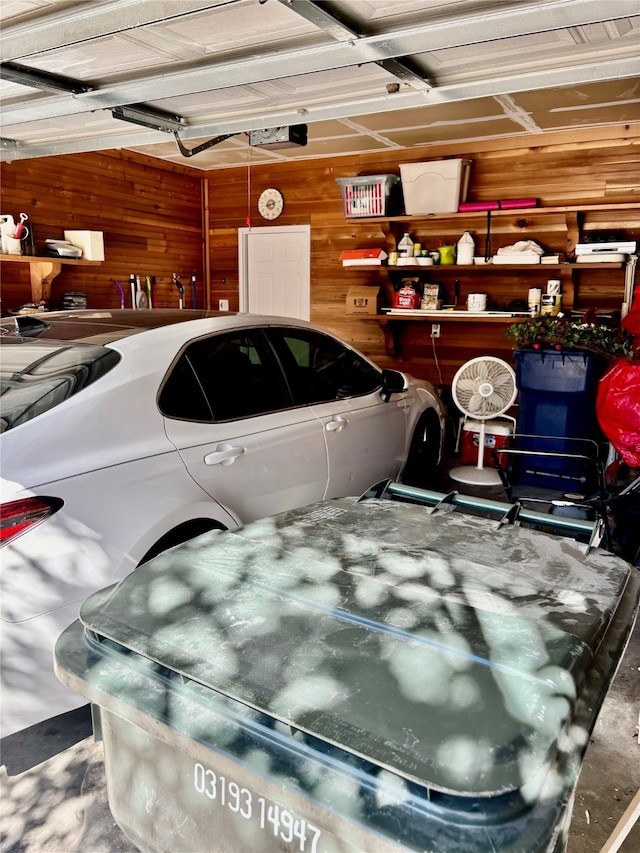 garage featuring wood walls and a garage door opener