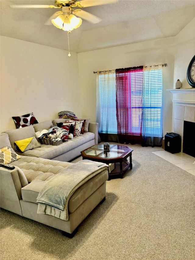 carpeted living room featuring a tiled fireplace and ceiling fan