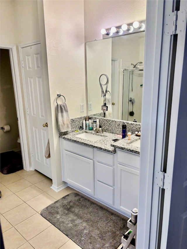 bathroom featuring vanity, walk in shower, and tile patterned floors