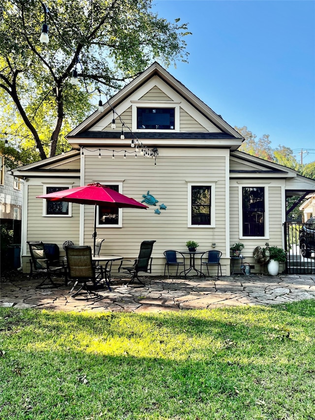 rear view of house featuring a patio area and a lawn