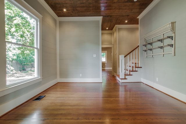 empty room with wood ceiling, plenty of natural light, and hardwood / wood-style floors