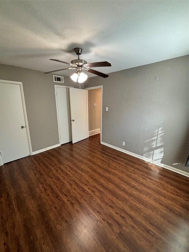 unfurnished bedroom featuring a textured ceiling, dark hardwood / wood-style floors, and ceiling fan