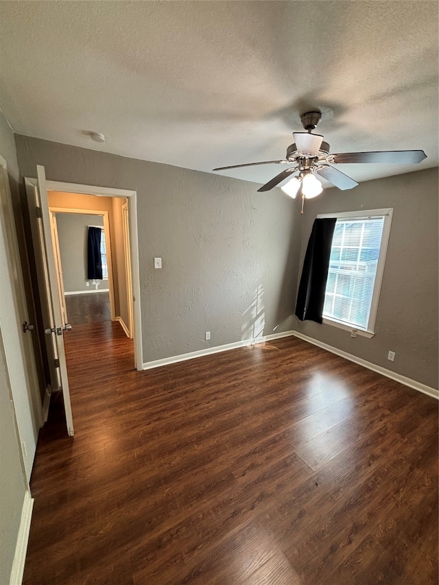 unfurnished room featuring ceiling fan, a textured ceiling, and dark hardwood / wood-style flooring