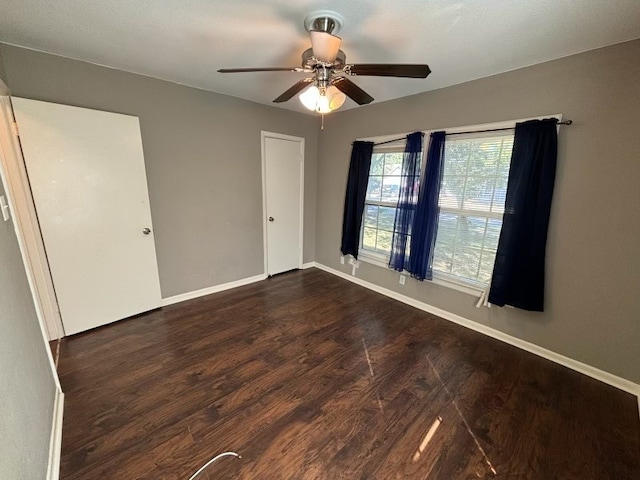 unfurnished room with ceiling fan and dark hardwood / wood-style floors