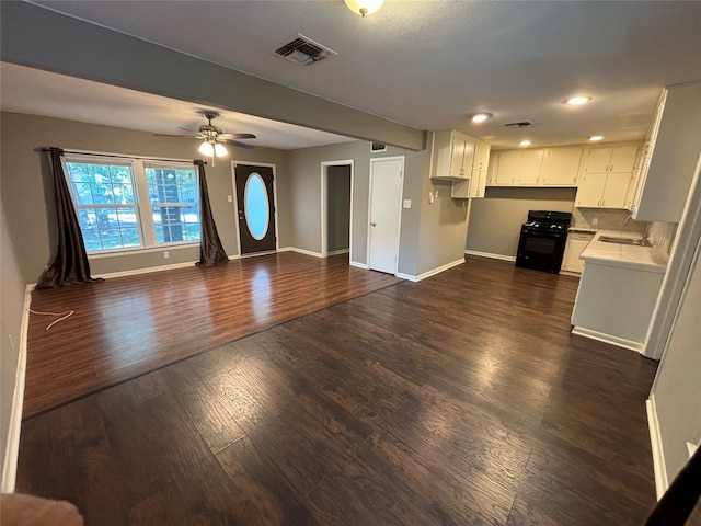 unfurnished living room with ceiling fan and dark hardwood / wood-style flooring