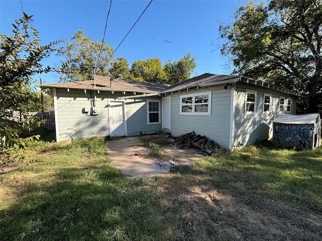 back of property with a yard and a shed