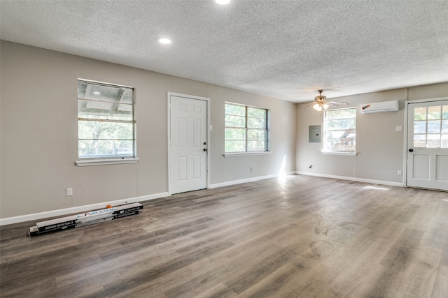 entryway with a wall mounted AC, wood-type flooring, plenty of natural light, and ceiling fan