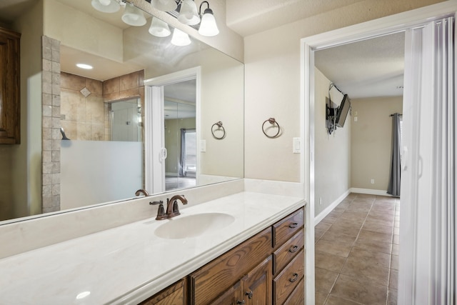 bathroom featuring vanity, a tile shower, and tile patterned floors