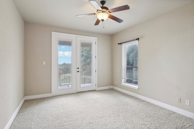 carpeted empty room featuring a wealth of natural light, french doors, and ceiling fan