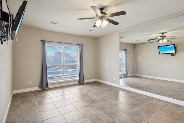 spare room featuring light tile patterned floors and ceiling fan