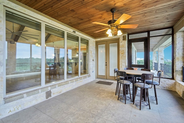 unfurnished sunroom with french doors, wood ceiling, and ceiling fan