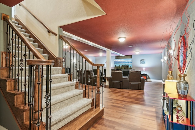 staircase featuring hardwood / wood-style floors and a textured ceiling