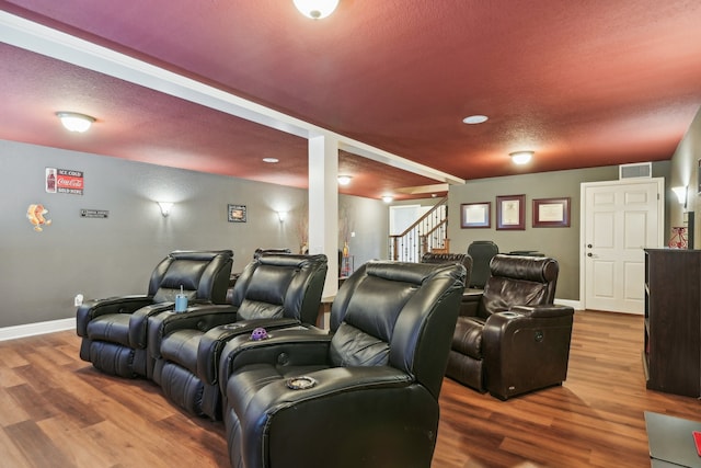 home theater with a textured ceiling and hardwood / wood-style floors