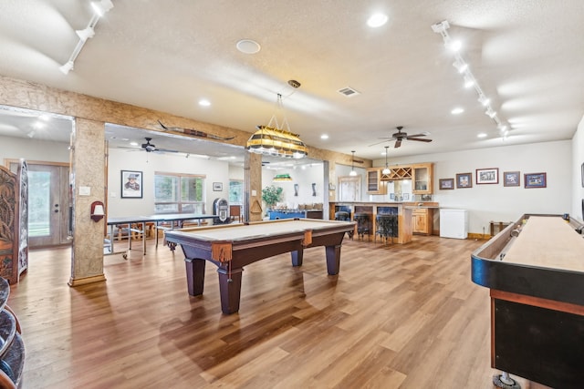 recreation room featuring track lighting, a textured ceiling, ornate columns, billiards, and light hardwood / wood-style flooring