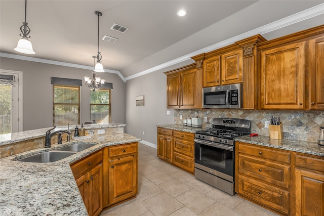 kitchen with appliances with stainless steel finishes, sink, hanging light fixtures, lofted ceiling, and a notable chandelier