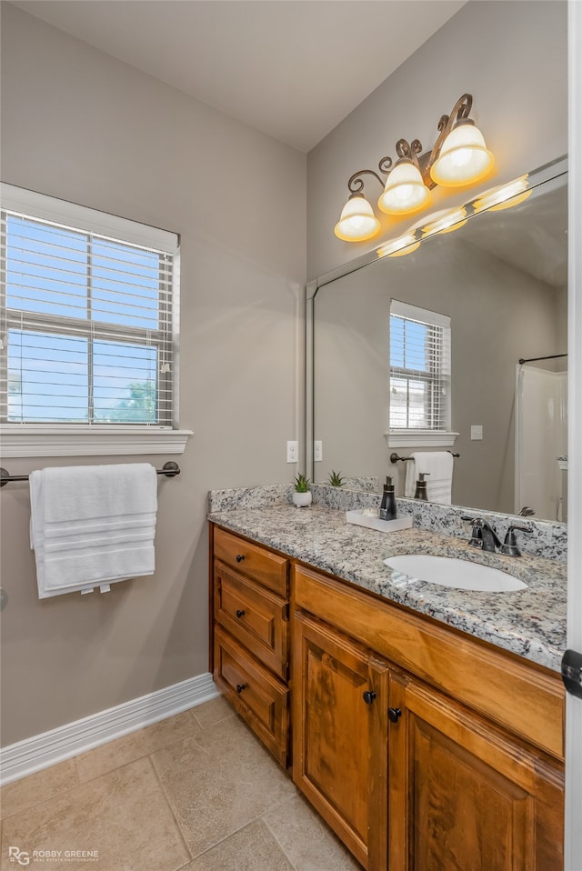 bathroom featuring vanity, a shower, and tile patterned flooring