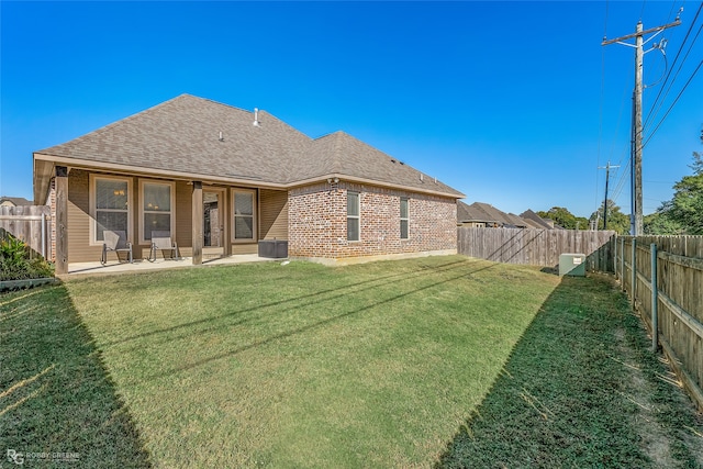 back of property featuring a patio area and a yard