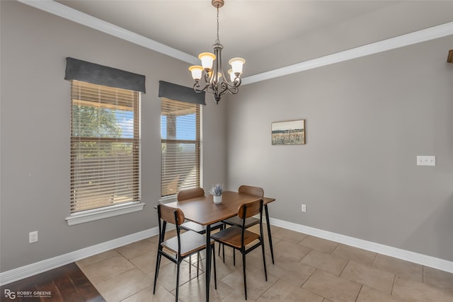 dining room with ornamental molding, light tile patterned flooring, and an inviting chandelier