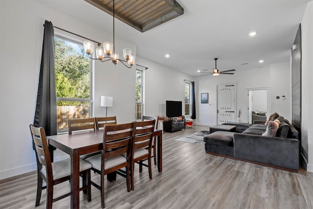 dining space with ceiling fan with notable chandelier and light wood-type flooring