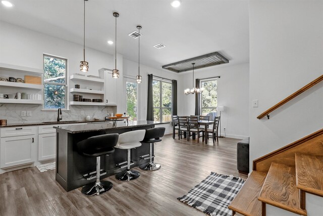 kitchen with a breakfast bar, white cabinetry, and a wealth of natural light